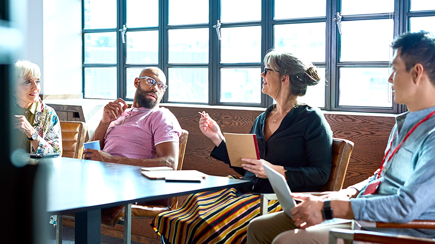 A racially diverse group of TD colleagues share ideas while seated around a table in a TD office.