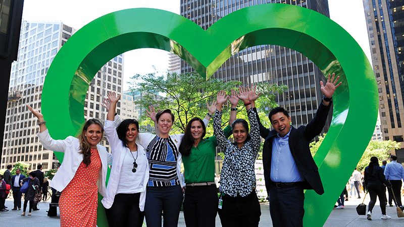 TD employees celebrate in front of heart-shaped sculpture