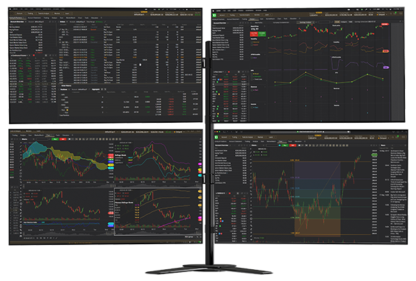 Four monitors showing trading data