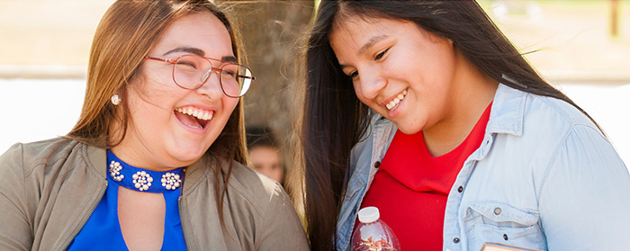 Two female indigenious students laughing