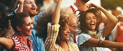 Three women smiling in a crowd