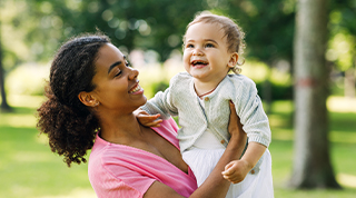 A smiling woman holding a laughing baby