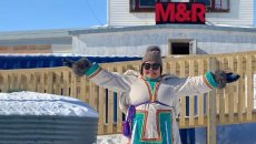 Woman from the Inuit community in traditional clothing, standing in front of a store in Nunavut