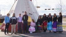 A group of people in front of a tipi