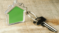 Une clé attachée à un porte-clés en forme de maison verte