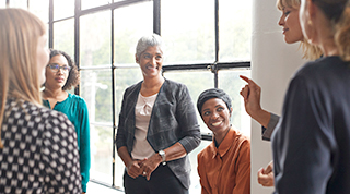 Un groupe de femmes diversifié se rencontre pour discuter d’affaires et de soutien communautaire.