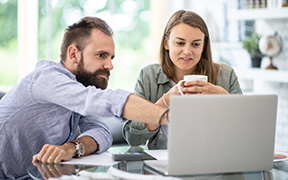 Un homme et une femme analysent des options de prêt hypothécaire en ligne
