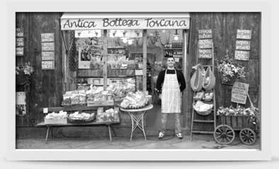 Image of man standing proudly in front of his store