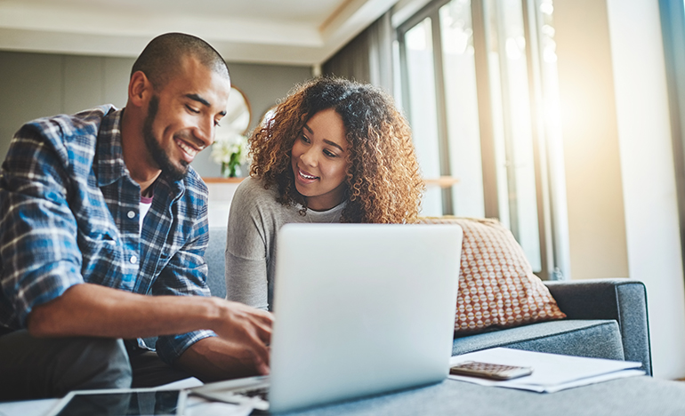 Shot of a young couple using a laptop while working on their home finances